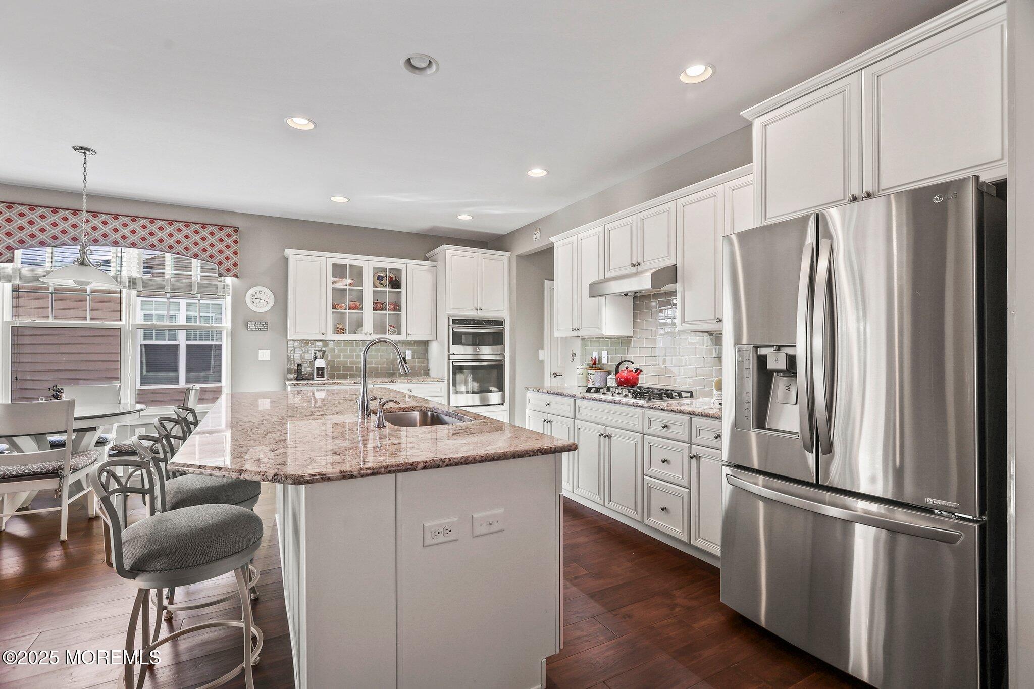 57 Harvest Ridge Road Howell, NJ 07731 - Photo 8 of 39 a kitchen with stainless steel appliances a refrigerator a stove a sink a dining table and chairs