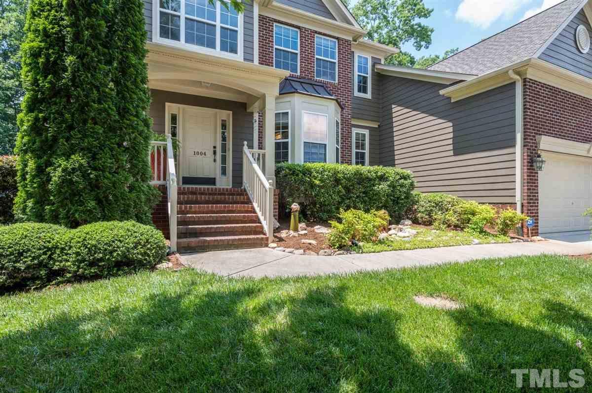 1004 Bianco Drive Raleigh, NC 27607 - Photo 2 of 30 a view of a house with brick walls and a yard with plants and large trees