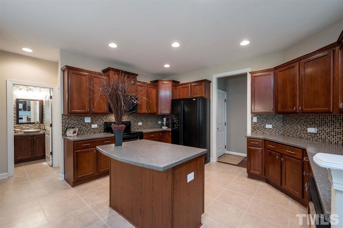 1004 Bianco Drive Raleigh, NC 27607 - Photo 8 of 30 a kitchen with kitchen island granite countertop stainless steel appliances and wooden cabinets