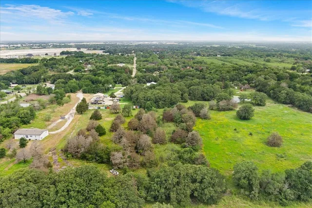 an aerial view of residential houses with outdoor space and trees