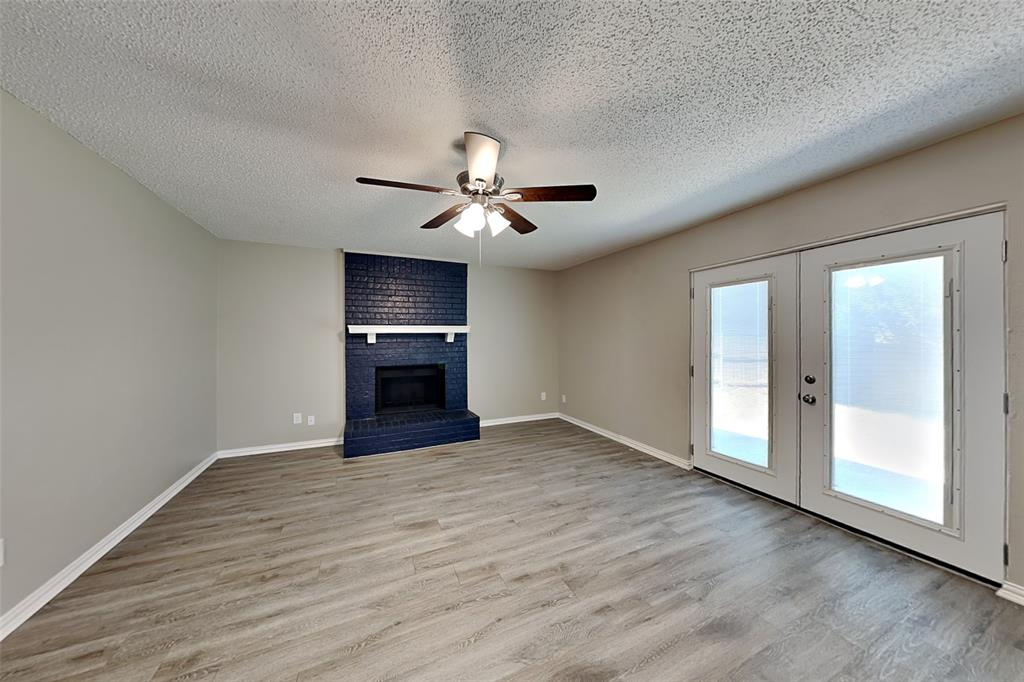 1504 Homestead Street Flower Mound, TX 75028 - Photo 5 of 22 an empty room with wooden floor chandelier fan and windows