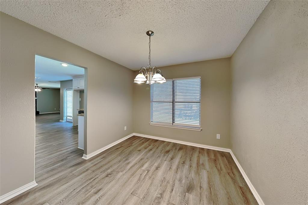 1504 Homestead Street Flower Mound, TX 75028 - Photo 9 of 22 a view of an empty room with wooden floor and a window