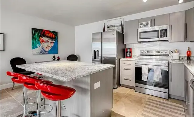 a kitchen with stainless steel appliances granite countertop a stove top oven a sink and dishwasher