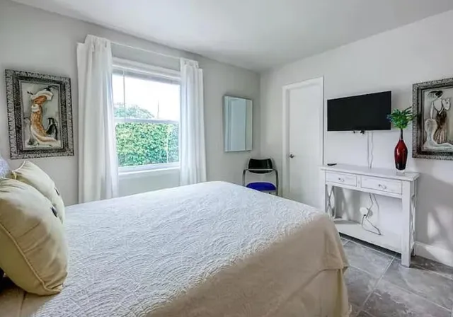 a bedroom with a bed and a flat screen tv