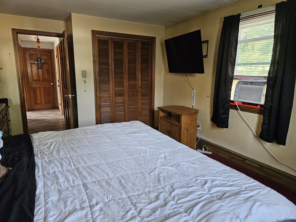 45 Dimmick Street Springfield, MA 01109 - Photo 15 of 22 a bedroom with a bed and a flat tv screen next to a window
