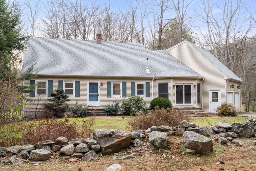 a front view of house with yard and trees around