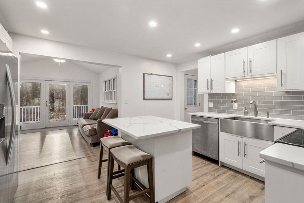 22 Dennison Cross Road Southbridge, MA 01550 - Photo 8 of 38 a large white kitchen with wooden floor and stainless steel appliances