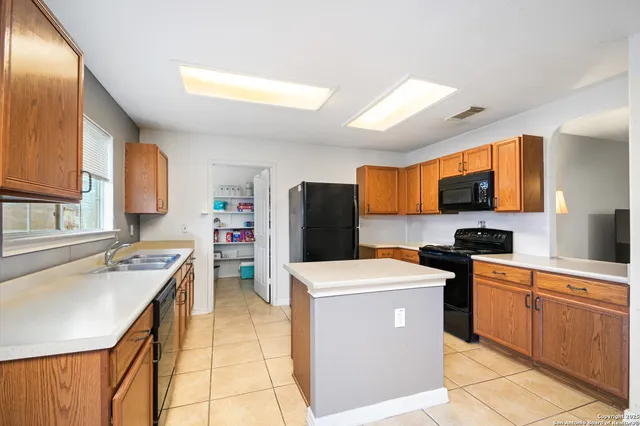 a kitchen with a stove a sink a microwave a counter top space and cabinets