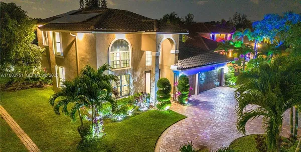 a front view of house and yard with beautiful flowers
