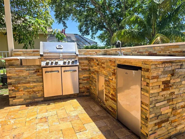 a kitchen with stainless steel appliances kitchen island granite countertop a stove refrigerator and microwave