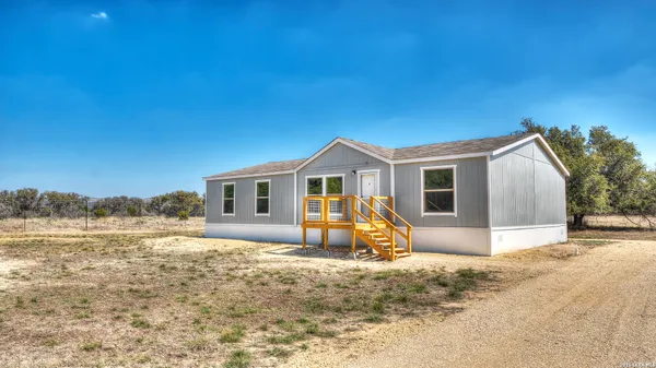 a view of a house with backyard and sitting area