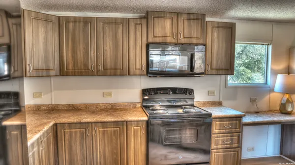 a kitchen with stainless steel appliances granite countertop a stove a microwave and cabinets