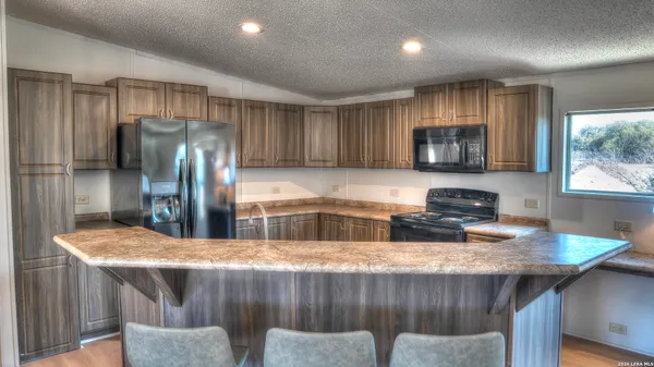 a kitchen with stainless steel appliances granite countertop a sink refrigerator and microwave