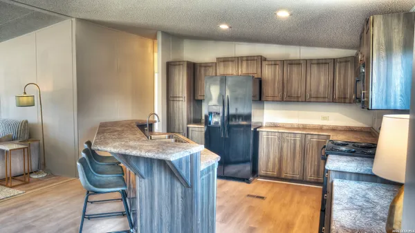 a kitchen with stainless steel appliances granite countertop a sink refrigerator and cabinets