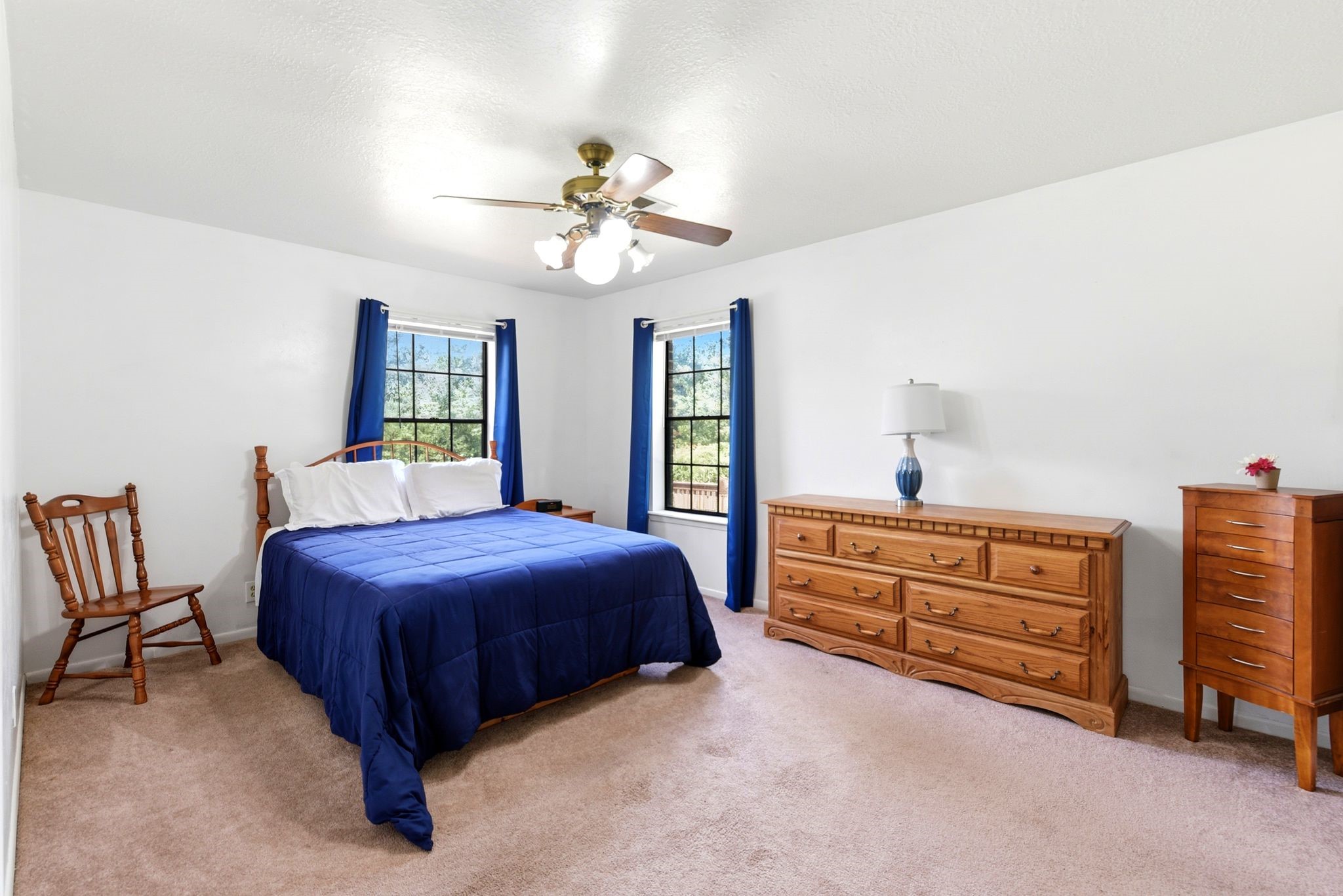 151 Parker Road New Waverly, TX 77358 - Photo 17 of 36 Spacious bedroom featuring large windows and ample storage provided by a wooden dresser set.
