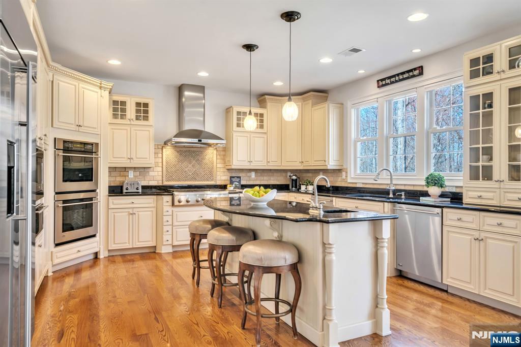 28 Arbor Road North Caldwell, NJ 07006 - Photo 23 of 50 a kitchen with stainless steel appliances granite countertop a stove and white cabinets