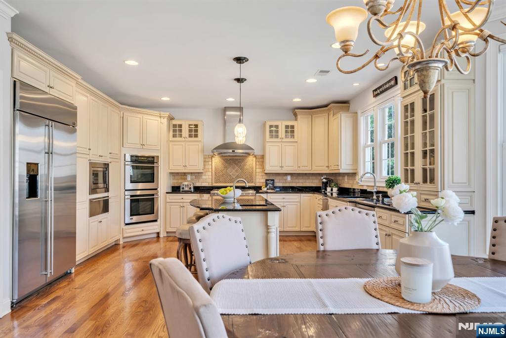 28 Arbor Road North Caldwell, NJ 07006 - Photo 27 of 50 a kitchen with stainless steel appliances kitchen island granite countertop a table chairs and a refrigerator
