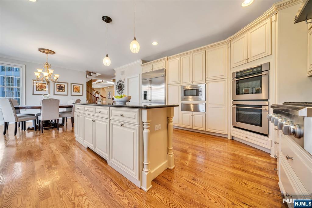 28 Arbor Road North Caldwell, NJ 07006 - Photo 28 of 50 a kitchen with stainless steel appliances kitchen island granite countertop a stove top oven a sink a dining table and chairs
