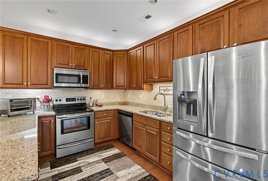 13712 Woodbridge Crossing Way Midlothian, VA 23112 - Photo 10 of 33 a kitchen with granite countertop stainless steel appliances and wooden cabinets