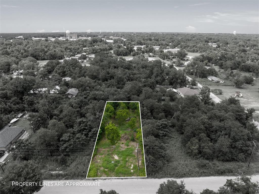 319 1st Street Marlin, TX 76661 - Photo 1 of 4 Aerial view of property's location featuring property parcel outlined and a heavily wooded area