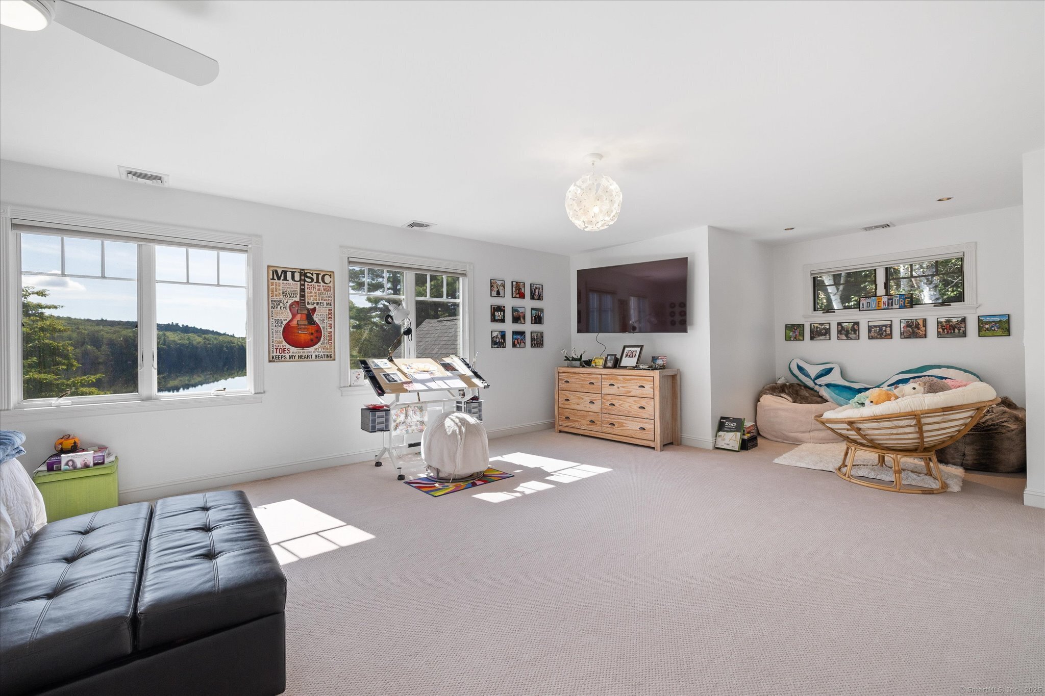 21-40 Howard Road Union, CT 06076 - Photo 19 of 40 a living room with furniture a flat screen tv and a floor to ceiling window