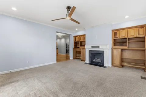 an empty room with fireplace cabinet and windows