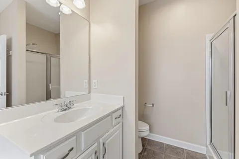 a bathroom with a granite countertop toilet a sink and a mirror