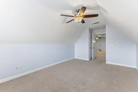 an empty room with closet and a chandelier fan