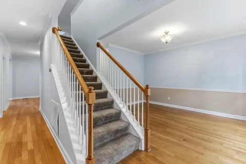 a view of a hallway with wooden floor and stairs