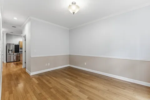 wooden floor in an empty room with a kitchen
