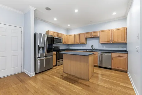 a kitchen with granite countertop a refrigerator and a stove top oven