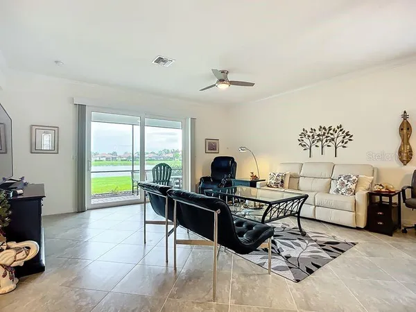 a living room with furniture a large window and a chandelier