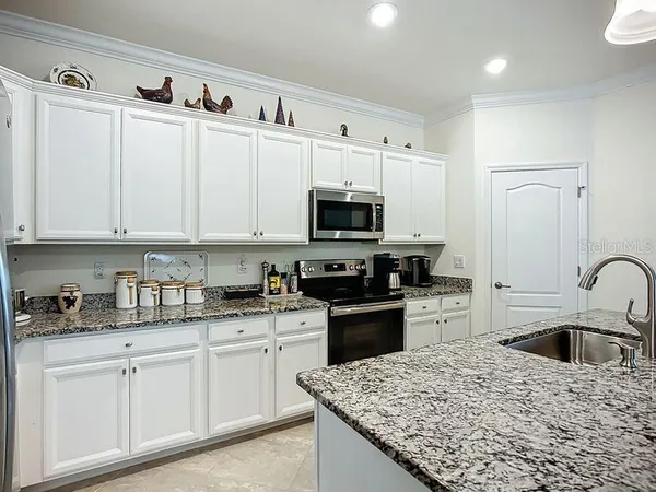 a kitchen with white cabinets sink and stainless steel appliances