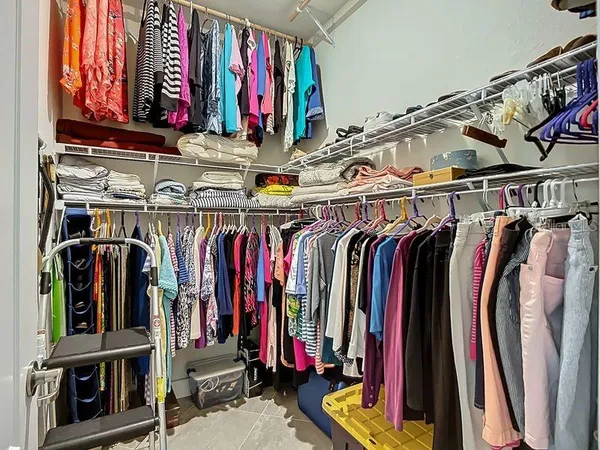 a view of walk in closet with clothes