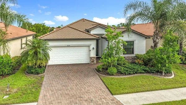 a front view of a house with a yard and potted plants