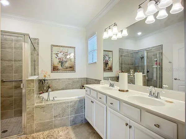 a bathroom with a double vanity sink a mirror and a bathtub