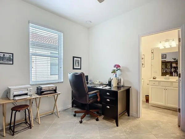 a view of a workspace with furniture and a window