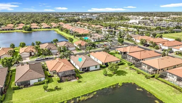 an aerial view of residential houses with outdoor space and lake view