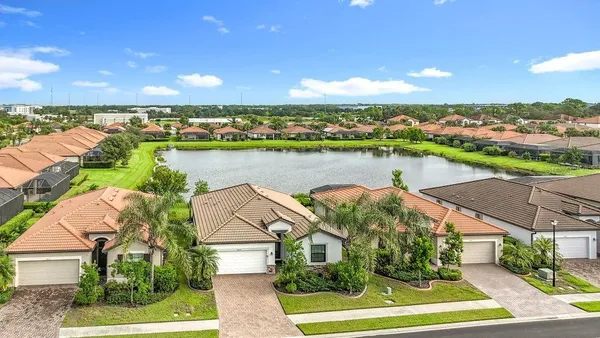 an aerial view of a house with outdoor space lake view and mountain view in back