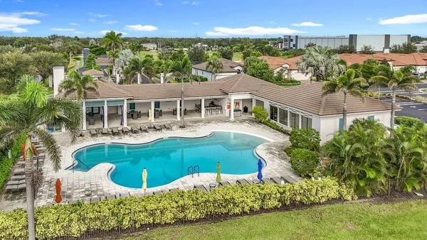 a view of a house with a swimming pool and sitting area