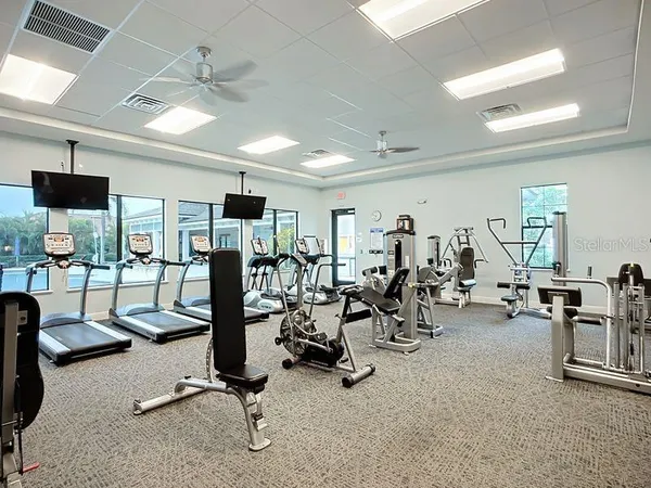 a room with gym equipment and large mirror