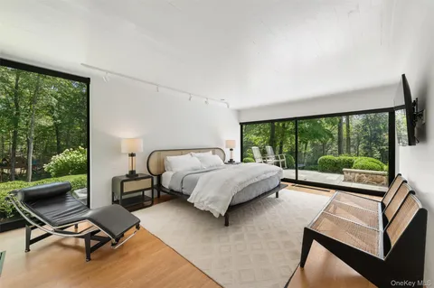 a bedroom with a bed and large windows