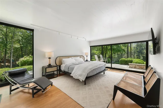 a bedroom with a bed and large windows