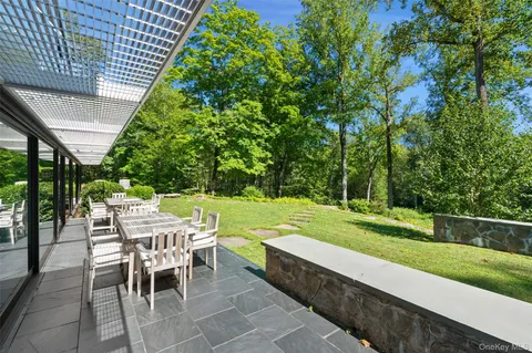 a view of backyard with seating space and trees