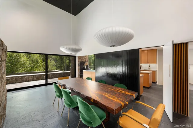 a dinning room with furniture and a floor to ceiling window