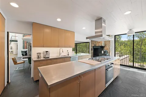 a kitchen with a stove a sink a microwave a dining table and chairs