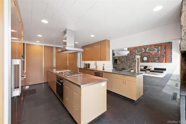 a kitchen that has a lot of cabinets in it and stainless steel appliances