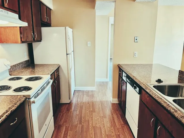 a kitchen with a sink a refrigerator and a stove