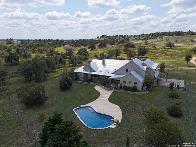 an aerial view of a house with yard swimming pool and outdoor seating