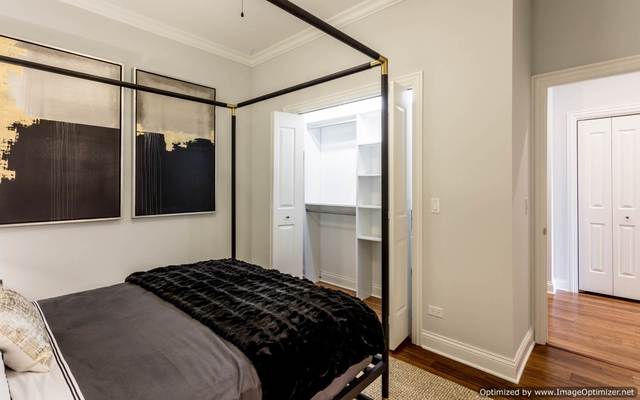 Undisclosed Address Chicago, IL 60607 - Photo 13 of 16 a bedroom with a bed and a walk in closet